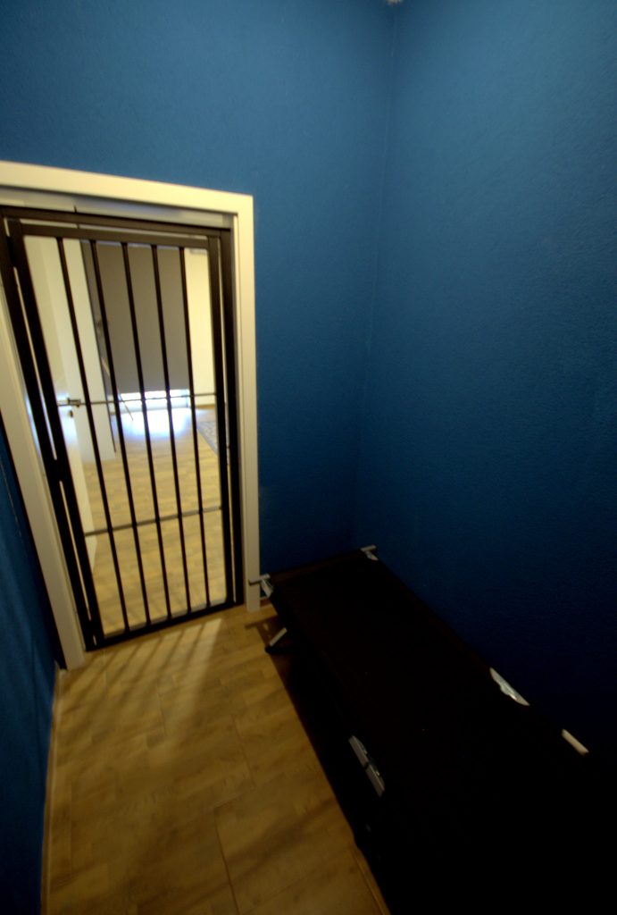 Zelle Gittertür Blick auf Schlafzimmer BDSM